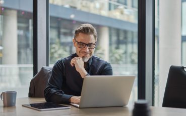 Businessman,Using,Laptop,Computer,In,Office.,Happy,Middle,Aged,Man,